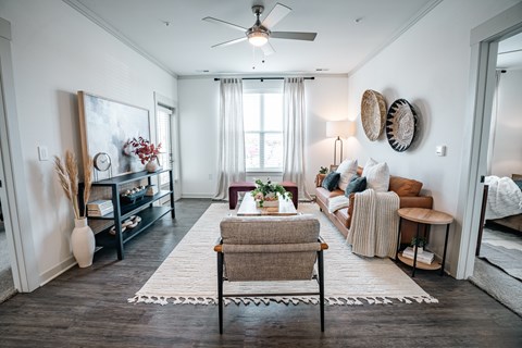 a living room with furniture and a ceiling fan